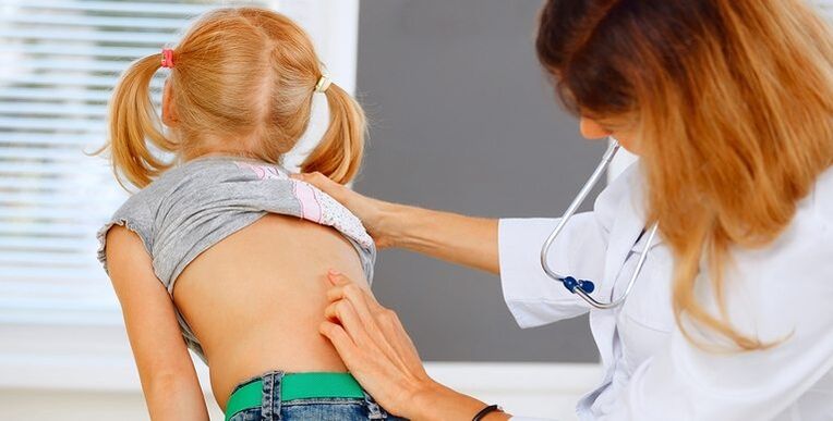 lekár, ktorý vyšetruje chrbát dieťaťa na bolesť dolnej časti chrbta